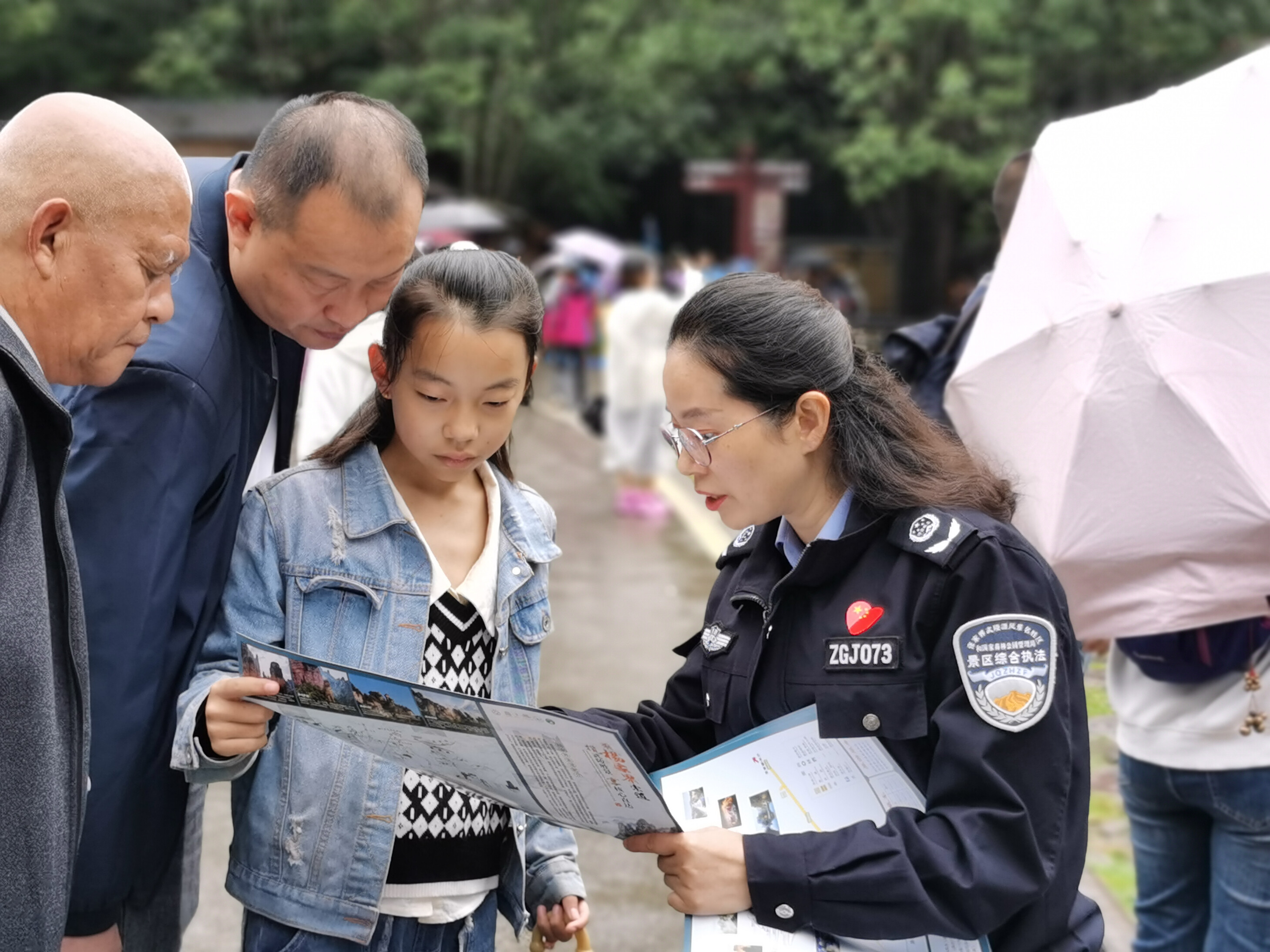 10月1日上年，金鞭溪景區(qū)管委會女子執(zhí)法隊隊員開展流動導(dǎo)覽服務(wù)，為游客免費贈送地圖。張娜 攝